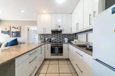 a kitchen with white cabinets and a counter top at 4 Serene Palms in Cape Town