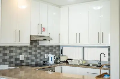 a kitchen with white cabinets and a sink at 4 Serene Palms in Cape Town