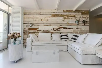a living room with a white couch and a wooden wall at Dolphin Hill Apartment, Cape Town, Dolphin Beach in Cape Town