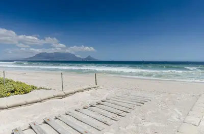 a sandy beach with a row of steps in the sand at Dolphin Hill Apartment, Cape Town, Dolphin Beach in Cape Town