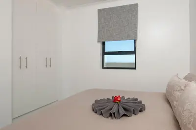 a room with a couch with a flower on it at Perlemoen Apartments in Hermanus