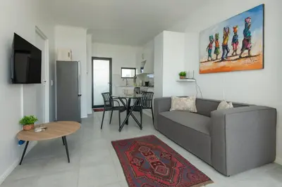 a living room with a couch and a table at Perlemoen Apartments in Hermanus