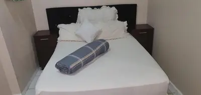 a white bed with a pillow and pillows on it at Skyway Sleep and go in Cape Town