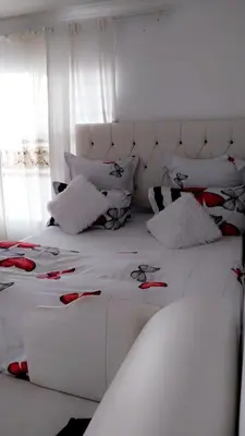 a white bed with a white headboard and pillows at Hussein accommodation in Cape Town