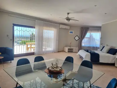 a living room with a glass table and a bed at Grace Space in Plattekloof in Cape Town