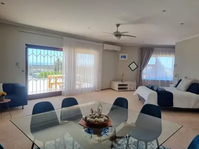 a living room with a glass table and a bed at Grace Space in Plattekloof in Cape Town
