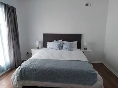 a bedroom with a large bed with a gray blanket at Azzure Apartments 3 sleeper Strand in Strand
