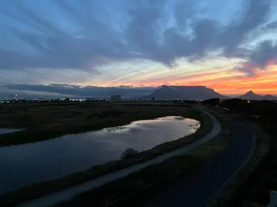 a river with the sunset in the background at Serene loft apartment in Cape Town