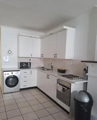 a kitchen with white cabinets and a stove and a dishwasher at Azzure Apartments 4 sleeper Strand in Strand