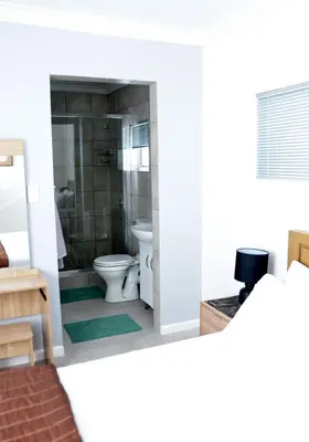 a white bathroom with a toilet and a shower at Harbour View in Cape Town