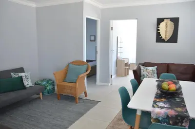 a living room with a couch and a table and chairs at Harbour View in Cape Town