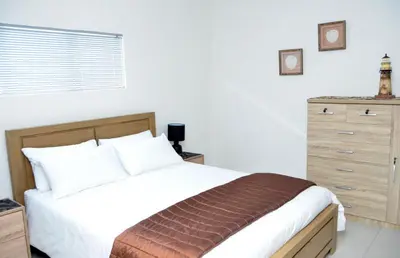 a bedroom with a large bed and a dresser at Harbour View in Cape Town