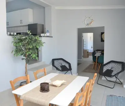 a dining room with a white table and chairs at Harbour View in Cape Town