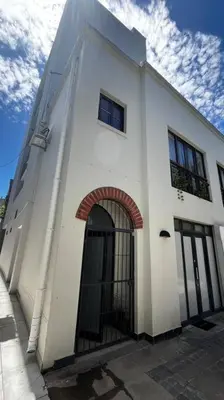 a white building with an archway on the side of it at Cosy Central Apartment - By ARPA Hospitalities in Stellenbosch