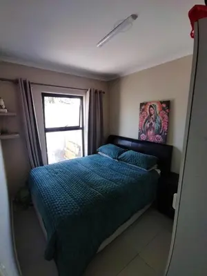 a bedroom with a bed and a window at 21 Pin Oak Guest House in Cape Town