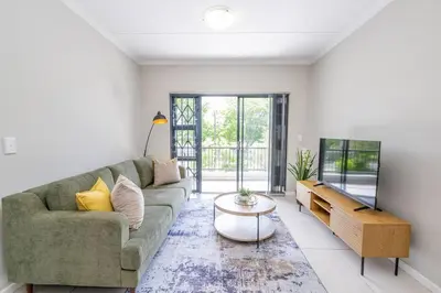 a living room with a couch and a table at Cozy Apartment in Brackenfell, Cape Town, ZA in Brackenfell