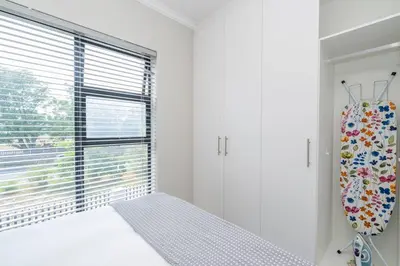 a bedroom with a bed and a large window at Cozy Apartment in Brackenfell, Cape Town, ZA in Brackenfell
