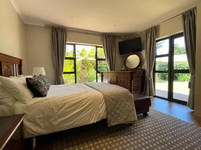 a bedroom with a bed and a large window at 7Pillars Villa Grenache in Durbanville