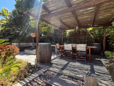 a wooden pergola with a table and chairs on a patio at 7Pillars Villa Grenache in Durbanville