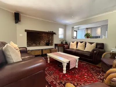 a living room with leather furniture and a fireplace at 7Pillars Villa Grenache in Durbanville