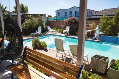 a small swimming pool with chairs and a bench at Luxurious Flatlet in the heart of Mowbray in Cape Town