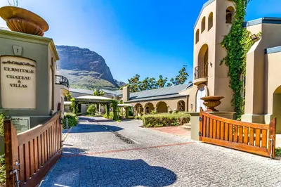 a street with buildings and a mountain in the background at W-Collection Franschhoek L'Ermitage Villas in Franschhoek