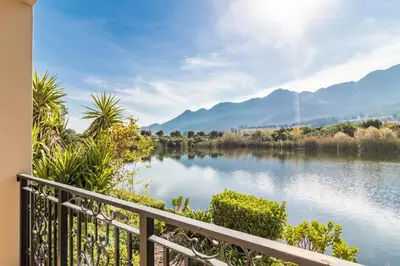 a view of a lake from a balcony at W-Collection Franschhoek L'Ermitage Villas in Franschhoek