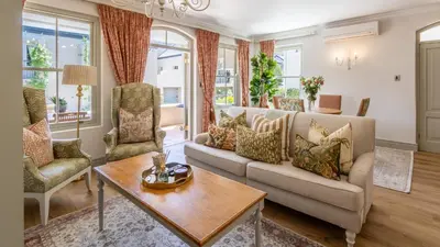 a living room with a couch and chairs and a table at W-Collection Franschhoek L'Ermitage Villas in Franschhoek