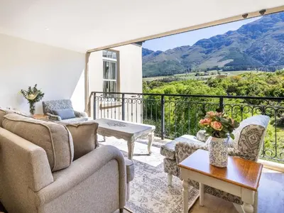 a living room with a couch and a table at W-Collection Franschhoek L'Ermitage Villas in Franschhoek