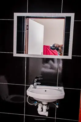 a mirror above a sink in a bathroom at Comfort on Wrench in Cape Town