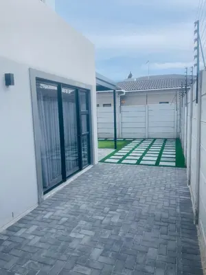 an empty driveway in front of a white house at Private Luxury Room by 29 Holborn in Cape Town