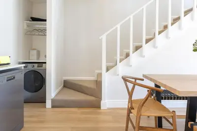 a kitchen with a wooden table and a stairway at 2D on Nansen in Cape Town