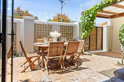 a patio with a wooden table and chairs at 2D on Nansen in Cape Town