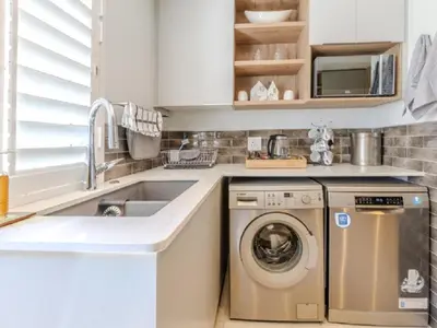 a kitchen with a washing machine and a sink at Hermanus - Heart of the Sea in Hermanus