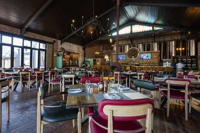 a restaurant with tables and chairs in a room at Franschhoek Hotel in Franschhoek