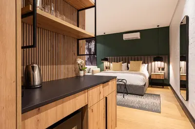 a bedroom with a bed and a room with a kitchen at Franschhoek Hotel in Franschhoek