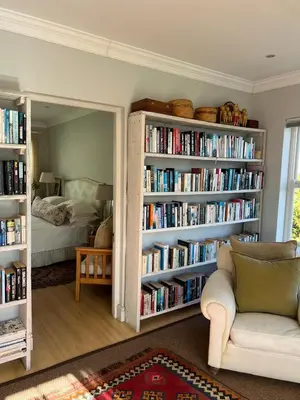 a living room with a book shelf filled with books at Sandpipers in Hermanus