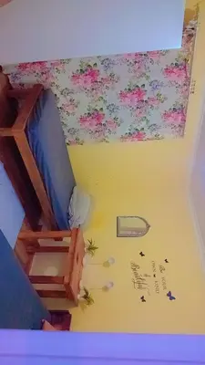 a room with a bed and a wall with flowers at Highbury Back Packers in Cape Town