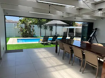 a dining room with a table and chairs and a pool at Luxurious 12 sleeper Appaloosa Villa in Cape Town