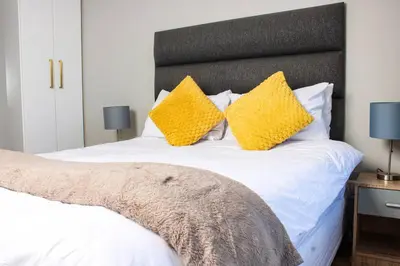 a bedroom with a white bed with yellow pillows at Ocean Palace Table View in Cape Town