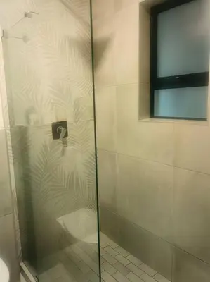 a shower with a glass door in a bathroom at Ocean Palace Table View in Cape Town