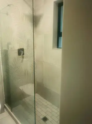 a shower with a glass door in a bathroom at Ocean Palace Table View in Cape Town