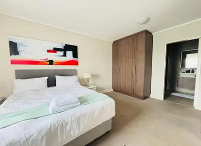 a bedroom with a bed and a painting on the wall at 6 sleeper apartment near Canal Walk in Cape Town