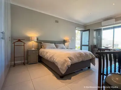 a bedroom with a bed with two lamps and a window at 7Pillars Shiraz in Durbanville