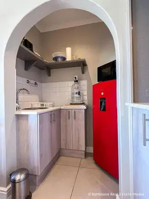 an archway in a kitchen with a red refrigerator at 7Pillars Shiraz in Durbanville