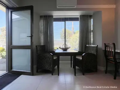 a dining room with a table and chairs and a window at 7Pillars Shiraz in Durbanville