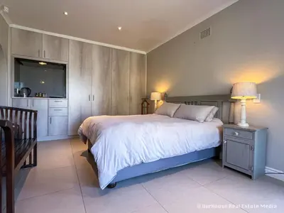 a bedroom with a large bed and a television at 7Pillars Shiraz in Durbanville