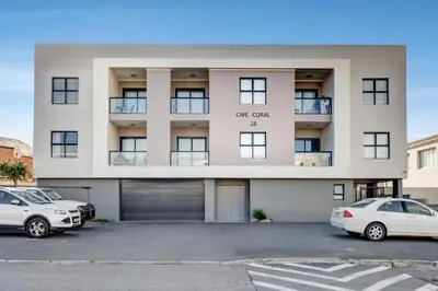 a white car parked in front of a building at Beachside Getaway in Cape Town