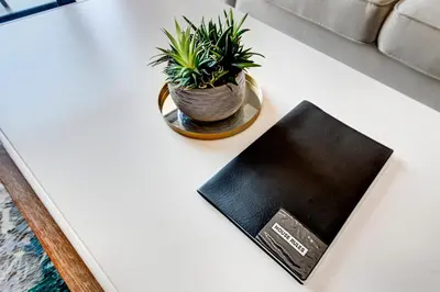 a book on a table with a potted plant on it at Beachside Getaway in Cape Town