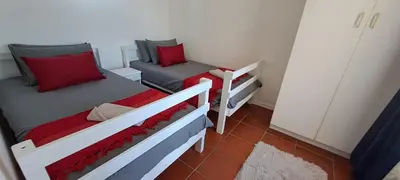 two beds in a small room with red pillows at Unit 75 Hermanus Beach Club in Hermanus